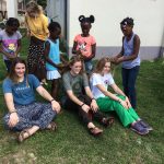 Local children braiding hair of short term missionaries on mission trip